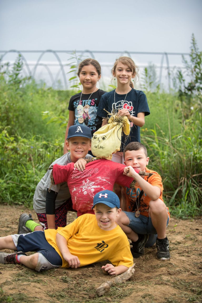 kids hanging out with scarecrow