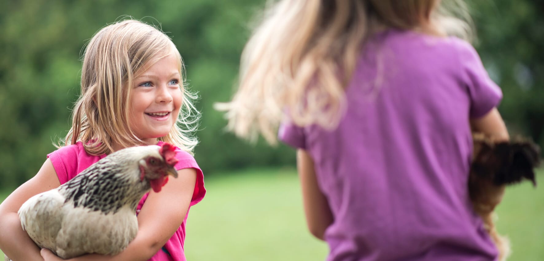 Young girl smiling and holding chicken